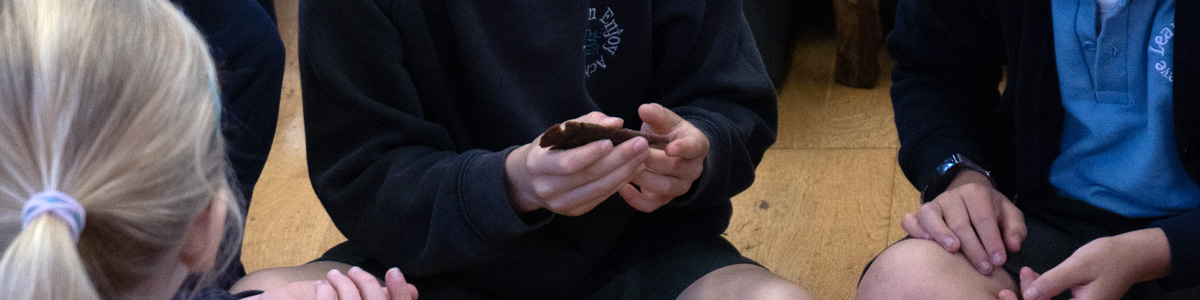A child handling a flint spearhead at a marvellous history prehistoric workshop