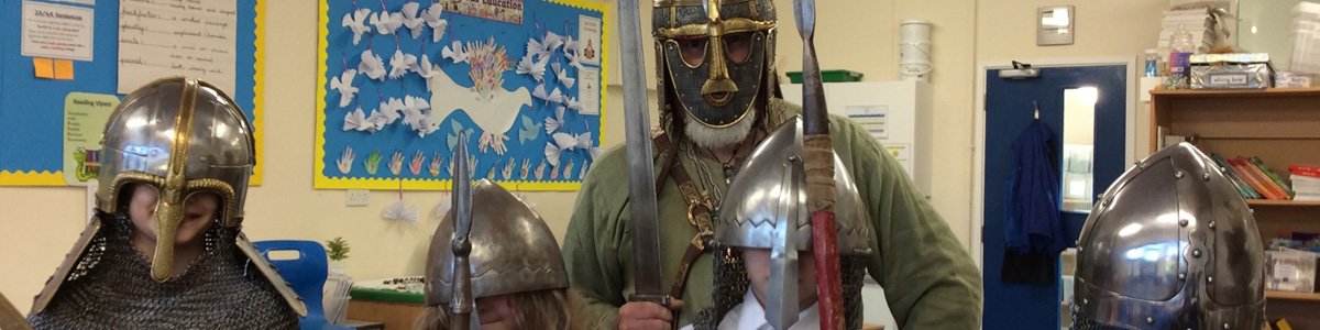 Anglo Saxon visitor posing with primary school children 