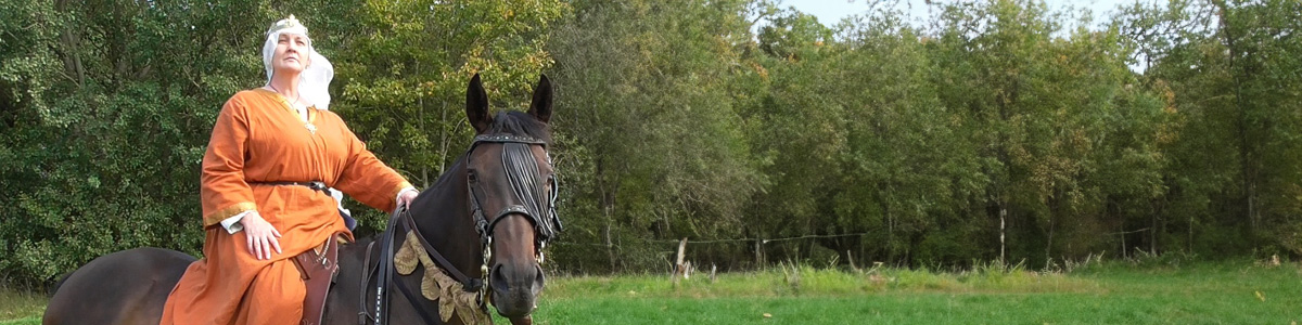 A woman dressed in medieval clothing on a horse 