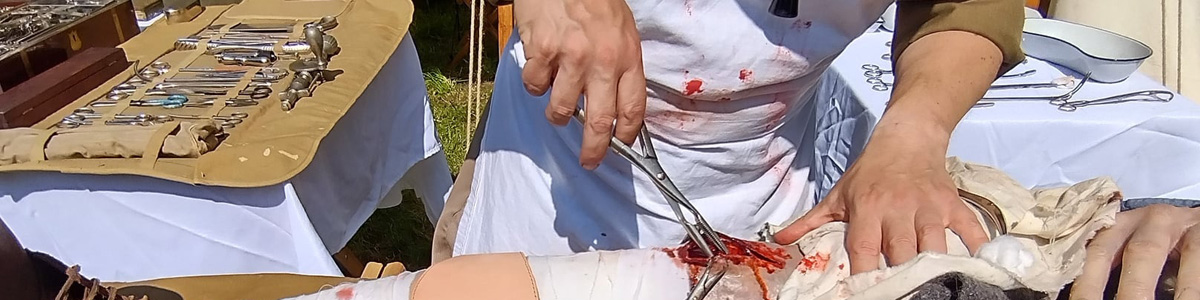 An image of a reenactor demonstrating what field surgery would have been in ww1